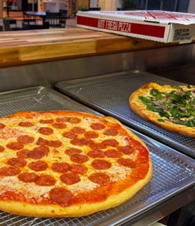 A fresh pepperoni pizza on a metal tray