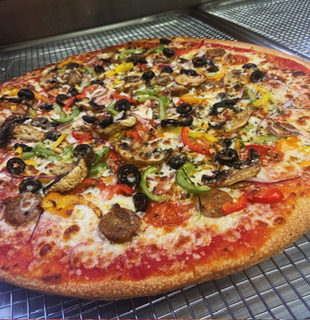 A supreme pizza loaded with toppings, fresh on the rack